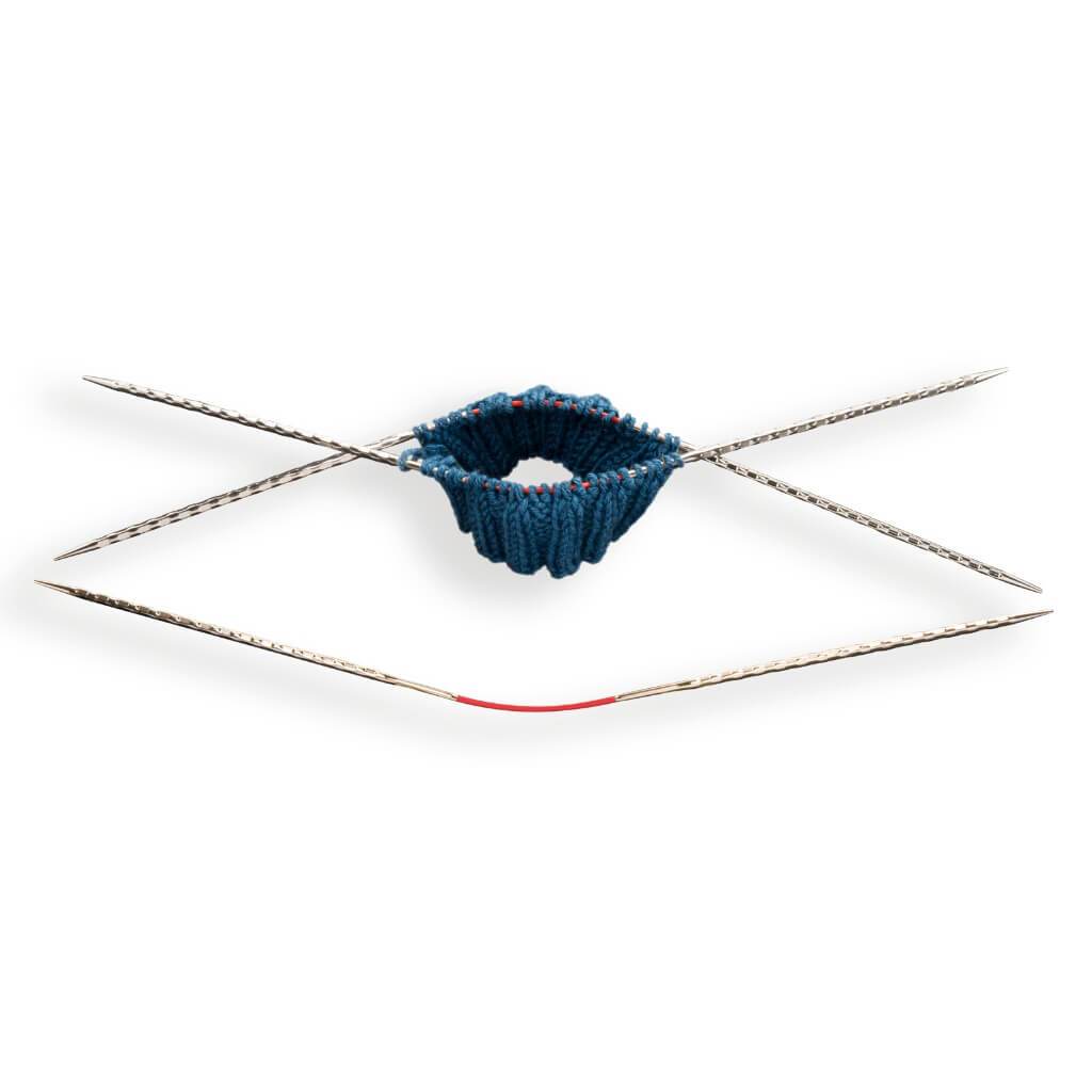addicrasytrio Nadeln mit angefangenem Strickprojekt aus blauem Garn.